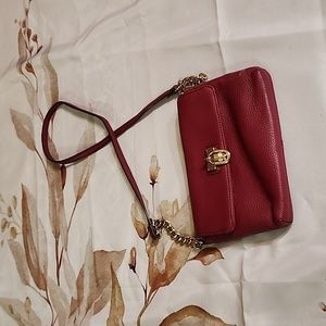 Red leather cross body bag dark bed